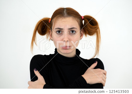 Closeup portrait of a sad redhead teenage girl with childish hairstyle looking offended isolated on white backround. Closeup portrait of a sad redhead teenage girl with childish hairstyle looking offended isolated on white backround. 125413503