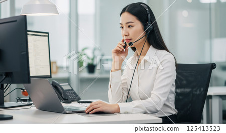 Japanese woman talking on a headset (AI generated image) 125413523