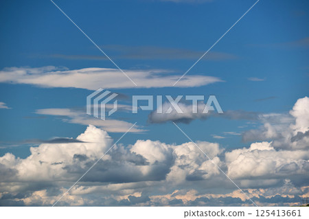 Bright landscape of white puffy cumulus clouds on blue clear sky. Bright landscape of white puffy cumulus clouds on blue clear sky. 125413661
