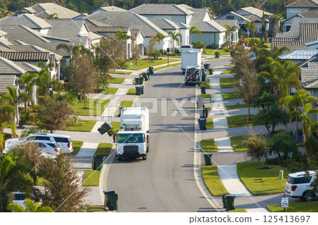 Automated modern garbage collector truck loading waste on Florida town street. Municipal services 125413697