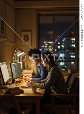 Japanese couple coding together at night (AI generated image) 125413737