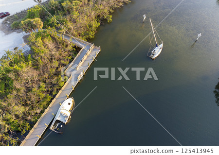 Aerial view of sunken sailboat on shallow bay waters after hurricane in Manasota, Florida 125413945