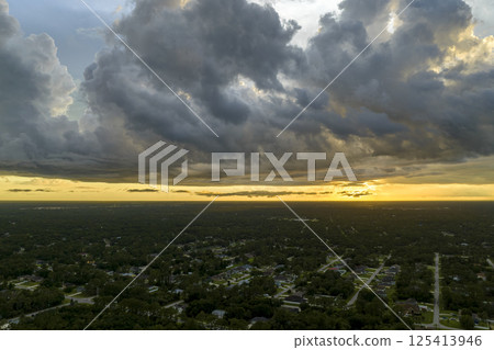 Aerial view of suburban landscape with private homes between green palm trees in Florida quiet residential area in evening 125413946