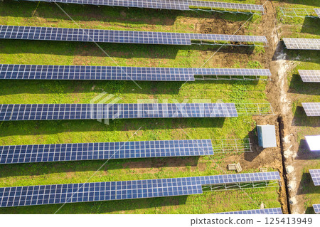 Aerial view of solar power plant under construction on green field. Assembling of electric panels for producing clean ecologic energy. 125413949