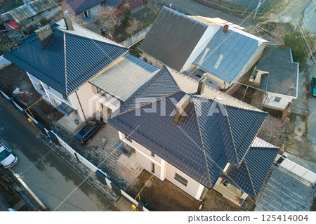 Aerial view of private house with ceramic shingles covered roof top. Investment in real estate concept 125414004