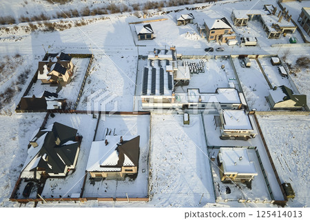 Aerial view of private homes with snow covered roofs in rural suburbs town area in cold winter 125414013