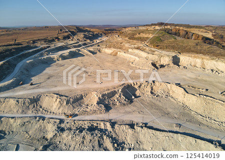 Aerial view of open pit mine of sandstone materials for construction industry with excavators and dump trucks. Heavy equipment in mining and production of useful minerals concept 125414019
