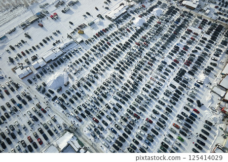 Aerial view of many cars parked for sale and people customers walking on car market or parking lot in winter 125414029