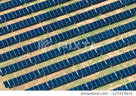 Aerial view of large sustainable electrical power plant with rows of solar photovoltaic panels for producing clean electric energy. Concept of renewable electricity with zero emission Aerial view of large sustainable electrical power plant with rows of solar photovoltaic panels for producing clean electric energy. Concept of renewable electricity with zero emission 125414032