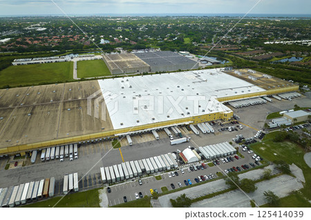 Aerial view of large commercial distribution center with many trucks unloading and uploading retail products for further shipment. Global economy concept 125414039