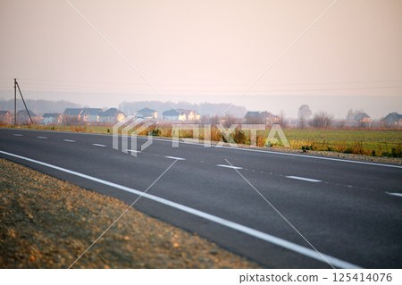 Aerial view of empty intercity road between green agricultural fields. Top view from drone of highway roadway 125414076