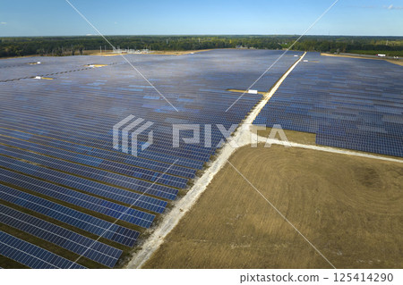 Aerial view of big sustainable electric power plant with many rows of solar photovoltaic panels for producing clean electrical energy. Renewable electricity with zero emission concept Aerial view of big sustainable electric power plant with many rows of solar photovoltaic panels for producing clean electrical energy. Renewable electricity with zero emission concept 125414290