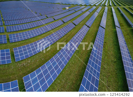 Aerial view of big sustainable electric power plant with many rows of solar photovoltaic panels for producing clean electrical energy. Renewable electricity with zero emission concept Aerial view of big sustainable electric power plant with many rows of solar photovoltaic panels for producing clean electrical energy. Renewable electricity with zero emission concept 125414292