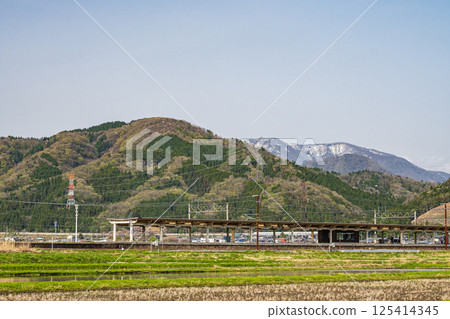Yogo Station on the Hokuriku Main Line and the green mountains in Yogo Town, Nagahama City, Shiga Prefecture 125414345