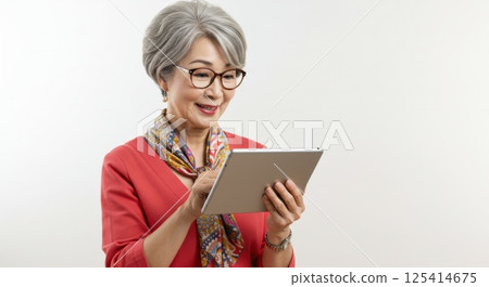 Senior Japanese woman using a tablet (AI generated image) 125414675