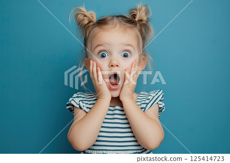 A little girl is making a very surprised face with her mouth open wide 125414723