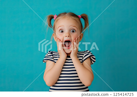 A little girl is making a very surprised face with her mouth open wide 125414725