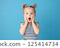A little girl is making a very surprised face with her mouth open wide 125414734