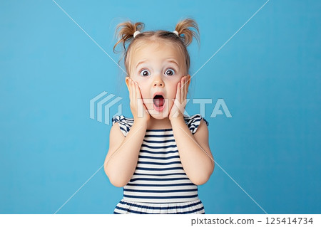 A little girl is making a very surprised face with her mouth open wide 125414734