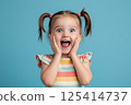 A little girl is making a very surprised face with her mouth open wide 125414737