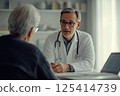 A doctor is engaged in a conversation with a patient in a hospital setting 125414739