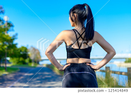 The back view of a cool woman exercising under the blue sky, looking back, diet, exercise, exercise 125414849