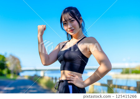 A cool woman exercising under the blue sky, fist pump, diet, exercise, exercise, trimming A cool woman exercising under the blue sky, fist pump, diet, exercise, exercise, trimming 125415266