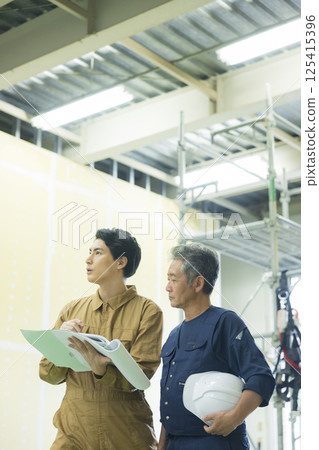 Site supervisors discussing plans at the site Site supervisors discussing plans at the site 125415396