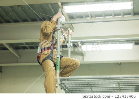 身穿全套安全帶的男性工人 身穿全套安全帶的男性工人 125415406