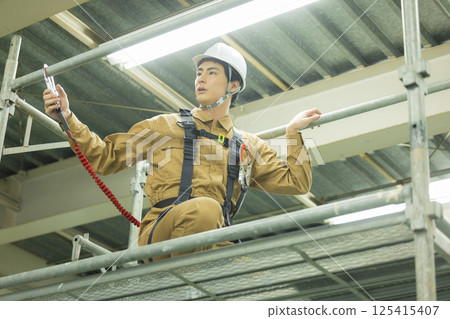 Male worker wearing a full harness Male worker wearing a full harness 125415407