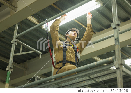 Male worker wearing a full harness 125415408