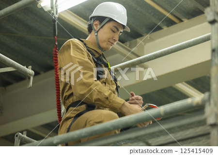 Male worker wearing a full harness Male worker wearing a full harness 125415409