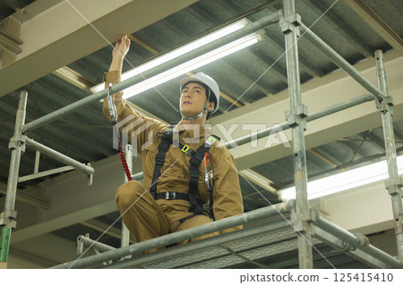 身穿全套安全帶的男性工人 身穿全套安全帶的男性工人 125415410