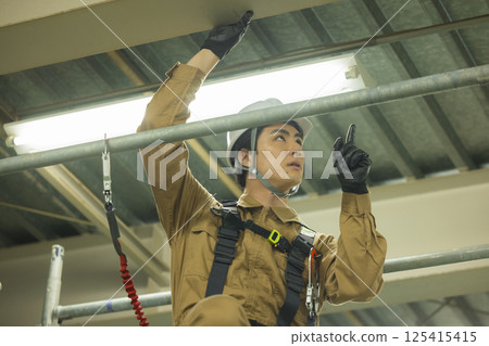 Male worker wearing a full harness Male worker wearing a full harness 125415415