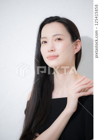Beauty and beauty image of a black-haired woman taking care of her neck and décolletage around her shoulders 125415858
