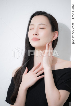 Beauty and beauty image of a black-haired woman taking care of her neck and décolletage around her shoulders Beauty and beauty image of a black-haired woman taking care of her neck and décolletage around her shoulders 125415861