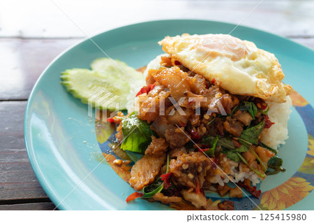 Stir-fried crispy pork with Thai basil and fried egg. Thai food Stir-fried crispy pork with Thai basil and fried egg. Thai food 125415980