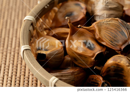 Close-up of black garlic (with skin) in a bamboo basket 125416366