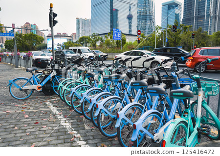 Shanghai, China - 1 April 2025: Rows of shared bicycles fill a parking area, highlighting Shanghai green transport solutions amid urban traffic promoting clean air and healthy urban living. 125416472