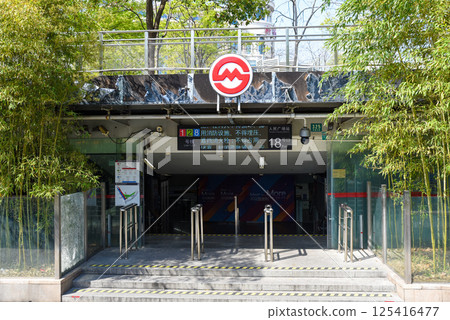 Shanghai, China - 1 April 2025: The entrance to People's Square Station (Exit 18) with bamboo groves in spring foliage. Sunny daylight highlights the contrast between urban infrastructure and natural Shanghai, China - 1 April 2025: The entrance to People's Square Station (Exit 18) with bamboo groves in spring foliage. Sunny daylight highlights the contrast between urban infrastructure and natural 125416477