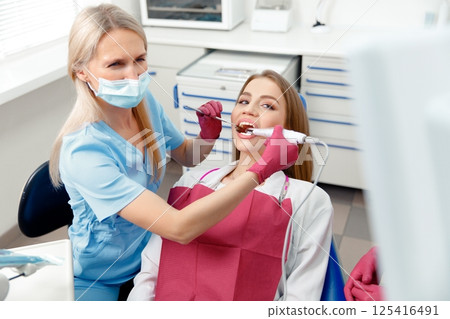 teeth whitening, dentist checking teeth, dental examination, patient's teeth, hospital office, ensuring dental health 125416491
