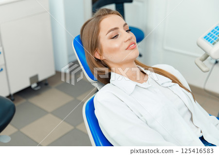 smiling dentist patient, dental chair, dentist patient, dentistry clinic, dental procedure, Smiling dentist communicating, dental instruments smiling dentist patient, dental chair, dentist patient, dentistry clinic, dental procedure, Smiling dentist communicating, dental instruments 125416583