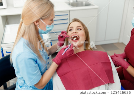 teeth whitening, dentist checking teeth, dental examination, patient's teeth, hospital office, ensuring dental health teeth whitening, dentist checking teeth, dental examination, patient's teeth, hospital office, ensuring dental health 125416626