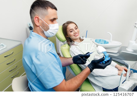 Dental treatment, Dentist checking teeth, dental examination, smiling woman, dental procedure, treating teeth, female at a dental clinic smiling 125416707