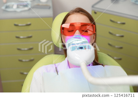 teeth whitening, Dentist starting teeth, whitening procedure, white teeth, receiving teeth cleaning teeth whitening, Dentist starting teeth, whitening procedure, white teeth, receiving teeth cleaning 125416711