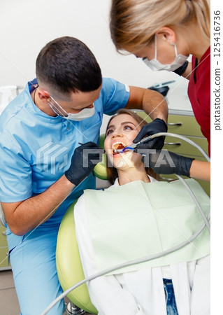 dental procedure, dentist chair, Dental treatment, smiling patient, female patient, Dentist examining treating teeth 125416736