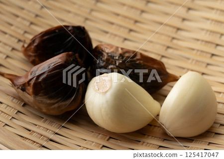 Black garlic with skin and peeled white garlic 125417047