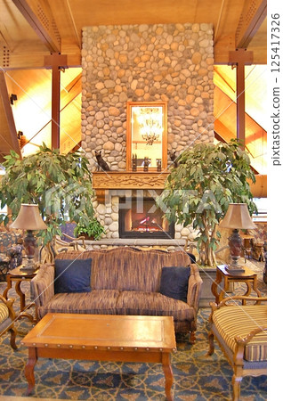 Cozy Rustic Lounge with a Stone Fireplace in a Lodge Cozy Rustic Lounge with a Stone Fireplace in a Lodge 125417326
