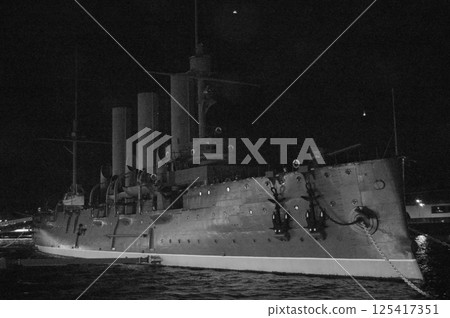 Battleship in the Darkness. A black-and-white nighttime photograph of a historic battleship. 125417351