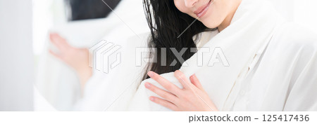 Woman towel drying her hair after a bath, faceless banner 125417436